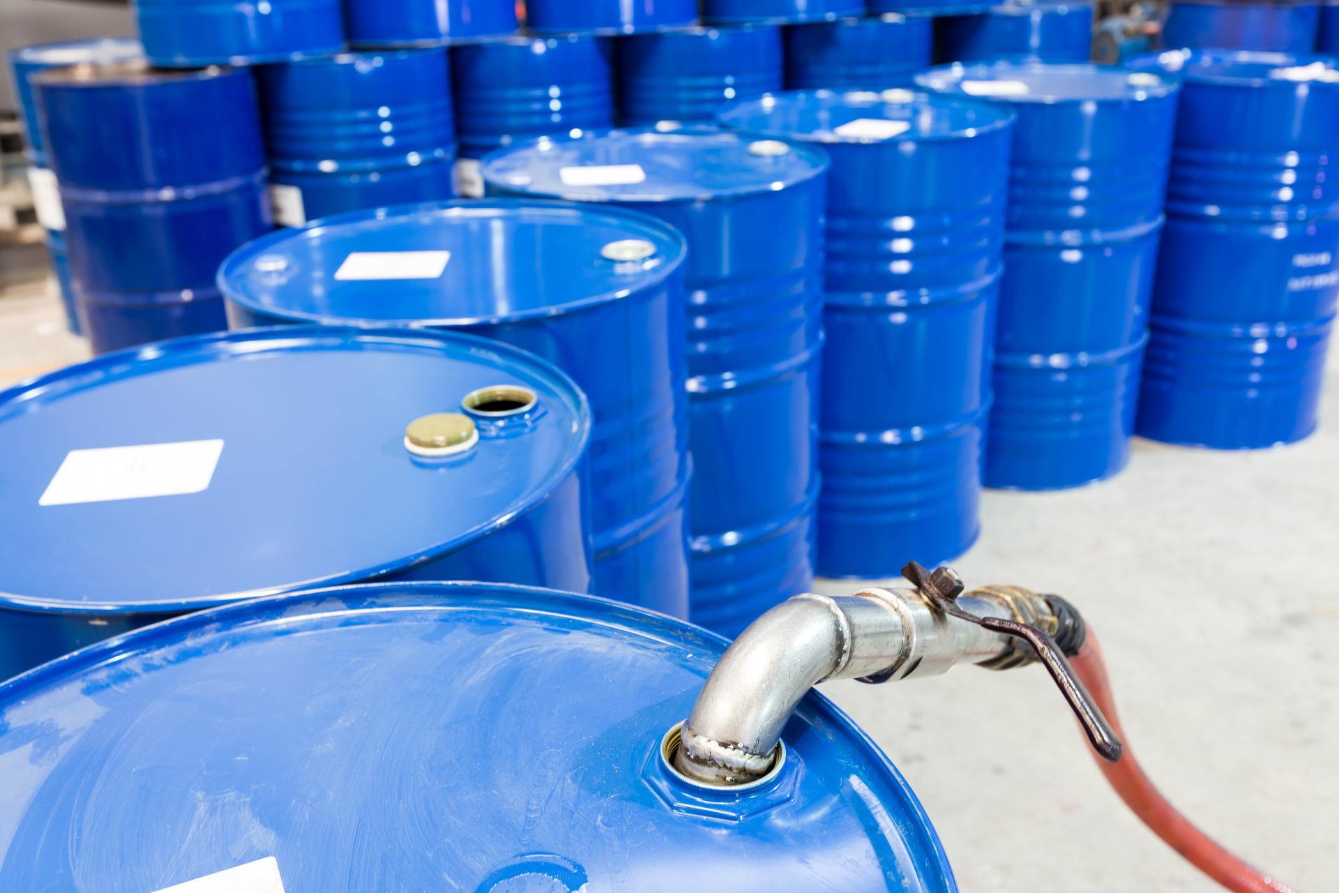 Blue steel drums staged for bulk liquid loading — industrial petroleum and specialty oil packaging for APAC procurement.