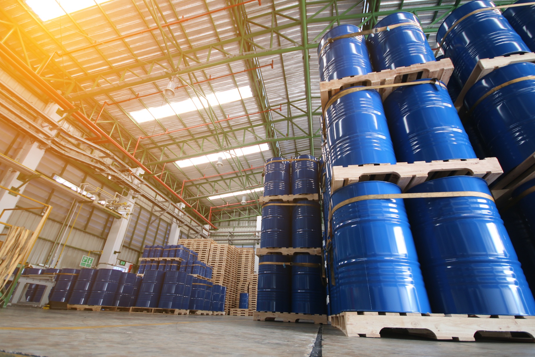 Palletised steel drums of industrial petroleum and base oil staged inside a bonded warehouse — APAC packaging and export readiness.